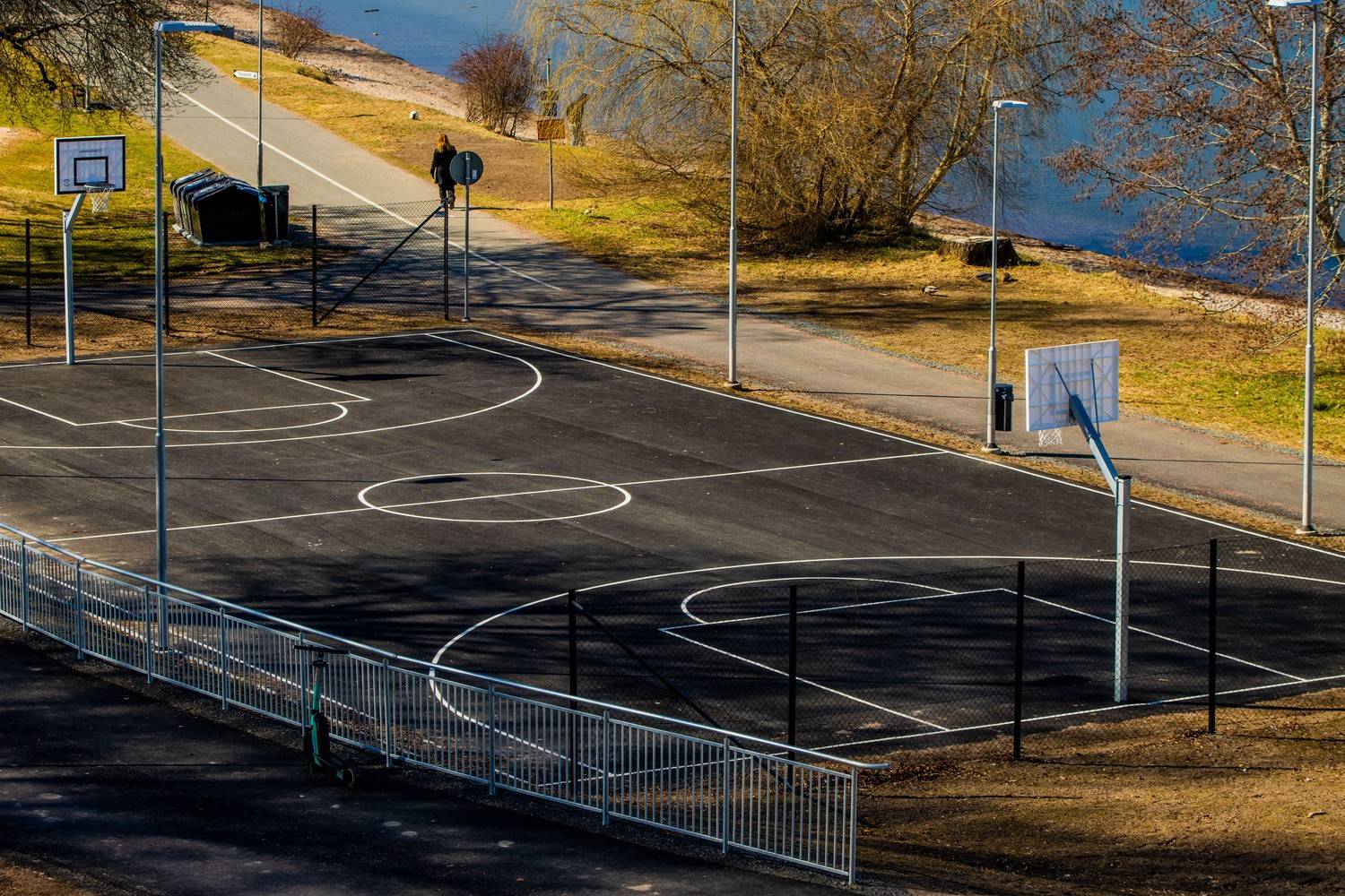Outdoor asphalt basketball court constructed and lined by Asphalt Services Inc. prior to the fall sports season.